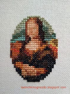 a close up of a cross - stitch picture of a person holding a baby jesus