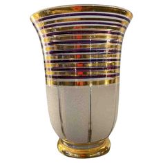 a glass vase with gold and purple stripes on it