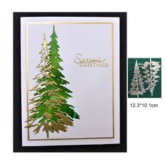 a christmas card with gold foiling and green pine trees on the front, and white background