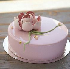 there is a pink cake with flowers on it