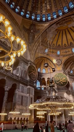 the inside of a large building with chandeliers and lights hanging from it's ceiling