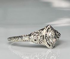 an antique style diamond ring with filigrees