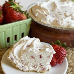 a piece of cake with whipped cream and strawberries next to it on a plate