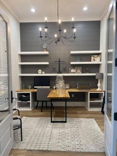 a home office with built in desks and shelving units on either side of the door