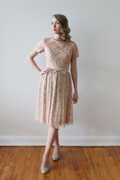 Vintage 1950's short sleeved dusty rose lace party dress with satin bow detail. Blush lace over blush fabric. A champagne satin fabric around the waist with blush lace over top. Satin champagne fabric bow in the front. Pleating in the skirt all around the waist. Dress in excellent condition!*Dress was pinned to fit model.MeasurementsApproximately a US women's size 4-6. Please check your own measurements and compare to those below. Model shown wears a dress size 2.Shoulders: 14" / Sleeve Length: Beige Short Sleeve Lace Dress For Wedding, Beige Lace Dress With Short Sleeves For Party, Beige Short Sleeve Lace Party Dress, 1950s Shorts, Champagne Fabric, Blush Fabric, Lace Party Dress, Top Satin, Lace Party Dresses