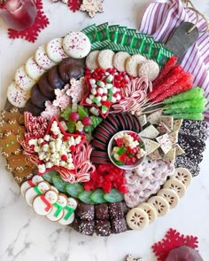 a platter filled with lots of different types of candy and cookies on top of a table