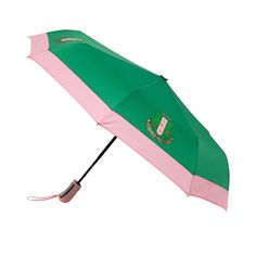 a green and pink umbrella with the coat of arms on it's handle is open