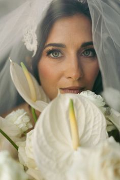 a woman wearing a veil with flowers in front of her