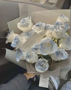 a bouquet of white roses sitting in the back seat of a car