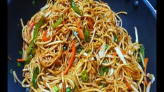 noodles and vegetables are mixed together in a blue bowl