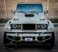 an american customs jeep is parked in front of a wooden fence