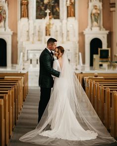 a bride and groom standing in front of the alter