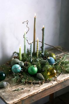 a wooden table topped with candles and ornaments