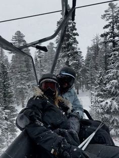 two people riding on a ski lift in the snow