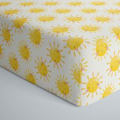 a yellow and white bed sheet with sun print