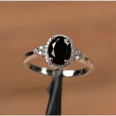 a black and white diamond ring sitting on top of a wooden table