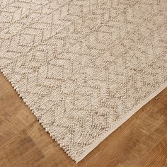 a white rug on top of a wooden floor