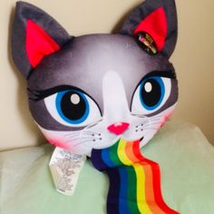 a stuffed cat is wearing a rainbow scarf