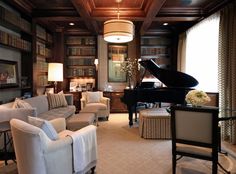 a living room filled with furniture and a grand piano in the middle of a library