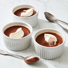 three small white bowls filled with chocolate pudding