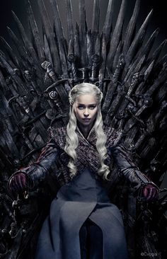 a woman sitting on top of a iron throne