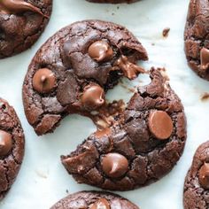 cookies with chocolate chips on top and one cookie broken in half, sitting on a white surface