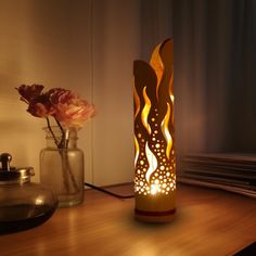 a lit candle sitting on top of a table next to a vase filled with flowers