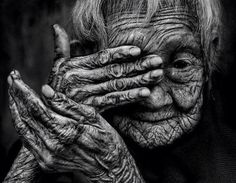 an old woman with wrinkles covering her face and hands, black and white photo