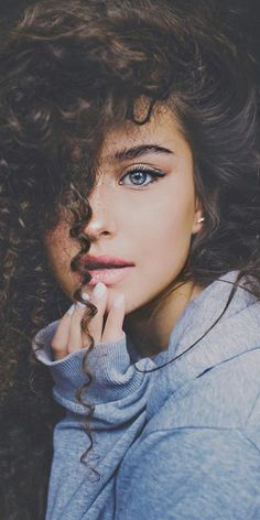 a woman with curly hair and blue eyes