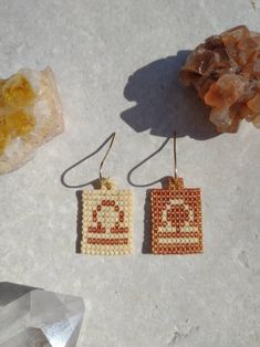 two small beaded earrings sitting next to each other