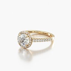 a yellow gold engagement ring with a round diamond center and pave set diamonds around the band