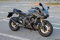 a black motorcycle parked in a parking lot