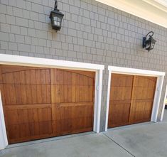 two wooden garage doors on the side of a building