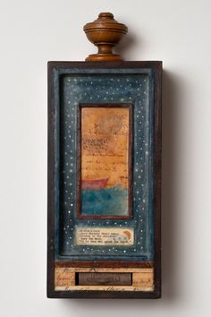 a wooden frame with writing on it hanging from the wall next to a white wall