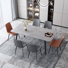 a dining room table with chairs and a rug on the floor in front of it