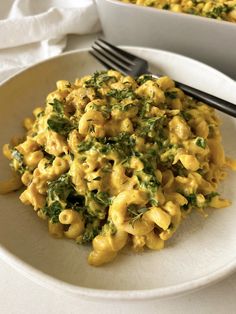 a white plate topped with macaroni and cheese next to a bowl of broccoli