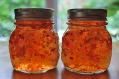 two jars filled with food sitting on top of a table