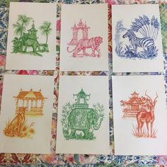 six cards with different designs on them sitting on a quilted tablecloth covered surface