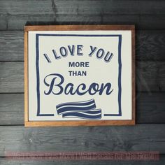 a sign that says i love you more than bacon hanging on a wooden plank wall