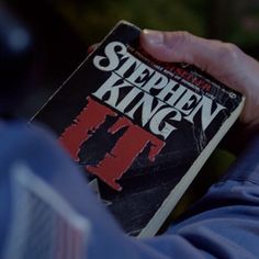 a person holding a book in their hands with the title stephen king written on it