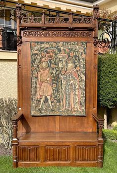 an old wooden bench with a painting on it's back side in front of a building