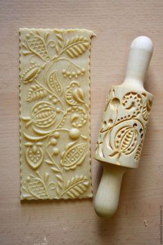 a rubber stamp with an ornate design on it next to a small piece of paper