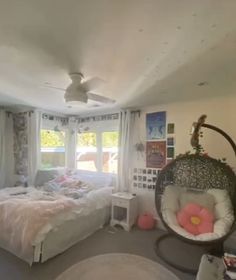 a bedroom with two beds and a hammock hanging from the ceiling in front of a window