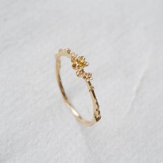 A beacon to the sun in the form of a yellow sapphire, held within the most delicate hand-carved buttercup petals. Glittering as the wind blows, and leaving a trail of gilt petals orbiting your finger. A fleur of pure whimsy, magical alone or mingling serendipitously in your stack. Available in 14k yellow, rose or white gold1.5mm yellow sapphire centre1mm band Your piece will be made-to-order—please allow 4 to 6 weeks for us to create the piece before shipping to you. Buttercup Ring, Laurie Fleming, Blue Green Sapphires, Green Sapphire, Pretty Rings, Engagement Ring Wedding Band, Dream Jewelry, Rose Cut Diamond, Pretty Jewellery