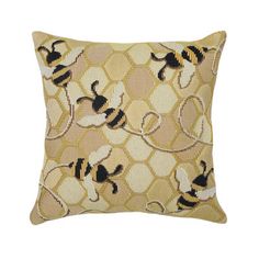 a yellow and black pillow with bees on the front, sitting on a white background