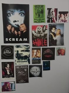 a refrigerator covered in posters and magnets next to a white freezer with the words scream on it