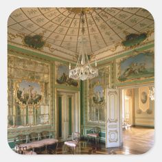 an ornately decorated room with chandelier and paintings on the walls, along with tables and chairs