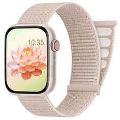 an apple watch with a white strap and flower on the front, showing its screen