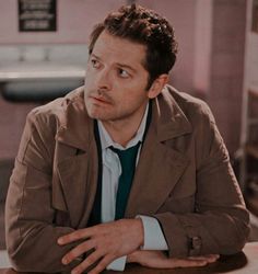 a man sitting at a table with his arms crossed