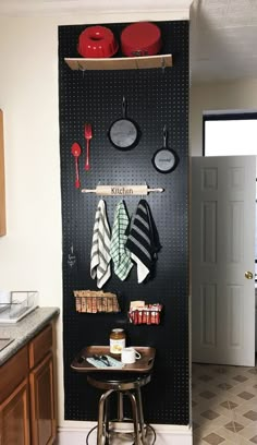 a kitchen area with pots and pans hanging on the wall, pot rack holding utensils